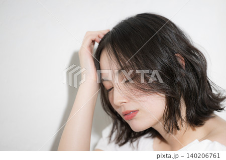 アンニュイな表情が魅力的な透明感のある素肌の若い女性のビューティーポートレート　ヘアケアや美容など 140206761