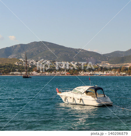 MY sailboat and coastal town with mountains in the background. Aegean sea water showing the vibrant blue color MY sailboat and coastal town with mountains in the background. Aegean sea water showing the vibrant blue color 140206879
