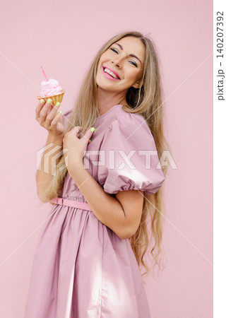Smiling Woman Celebrating Birthday With Cupcake Smiling Woman Celebrating Birthday With Cupcake 140207392
