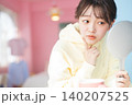 鏡を見て肌の状態を真剣にチェックする若い女性 140207525