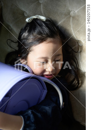 ソファに座ってランドセルを抱きしめる日本人の女の子 ソファに座ってランドセルを抱きしめる日本人の女の子 140207558