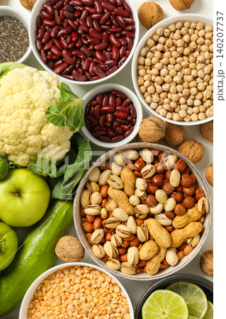 Different types of nuts and fruits placed on a clean surface 140207737