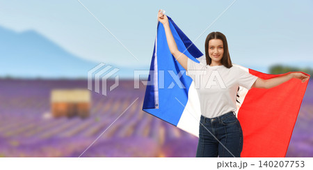 Young woman waves French flag in lavender field. Travel and cultural celebration concept 140207753