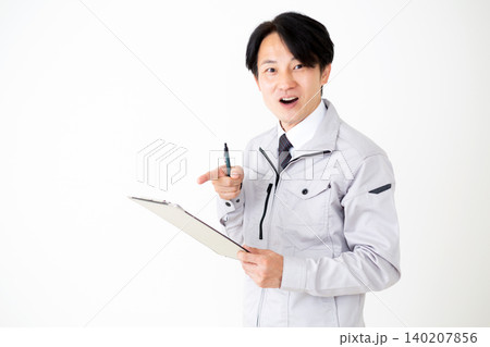 資料を見て驚くグレーの作業着のミドル男性ビジネスマン白バック 140207856