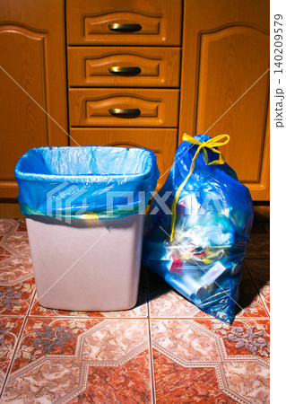New trash bag in garbage bin and full trash bag on home kitchen 140209579