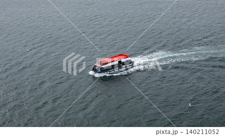 San Juan del Sur, Nicaragua - May 09, 2019: Touristic cruise tender boat in sea. Lifeboat vessel. Tender vessel of cruise ship with people inside. Touristic sea boat. Lifeboat floats on sea 140211052