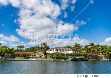 Residential apartment in waterfront. Waterfront landscape with house. Vacation building in summer. Luxury waterfront house. Serene waterfront view. Residential architecture and yacht. Modern building Residential apartment in waterfront. Waterfront landscape with house. Vacation building in summer. Luxury waterfront house. Serene waterfront view. Residential architecture and yacht. Modern building 140211082
