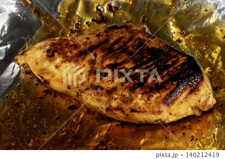 Roast chicken breast smothered in glaze and oils 140212419