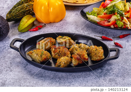 Chicken and vegetable fritters on a plate with fresh salad and ingredients Chicken and vegetable fritters on a plate with fresh salad and ingredients 140213124