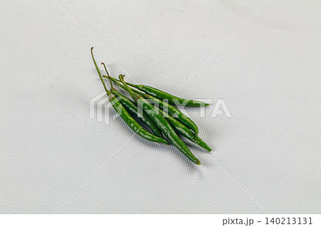 Fresh green chili peppers on white textured background Fresh green chili peppers on white textured background 140213131