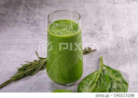 Healthy green smoothie with fresh spinach and rosemary on gray textured background 140213196