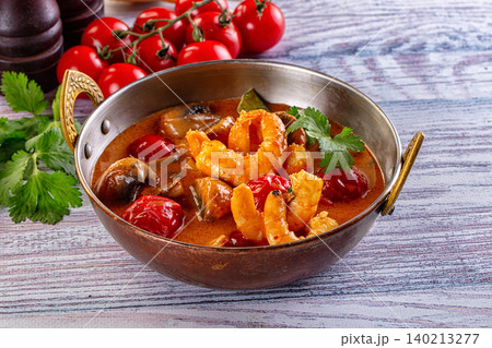 Spicy Thai Tom Yum soup with prawns and tomatoes in copper bowl 140213277