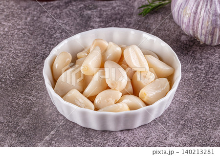 Peeled garlic cloves in white bowl 140213281