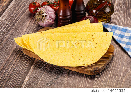 Yellow corn tortillas on wooden board with fresh vegetables and spices 140213334