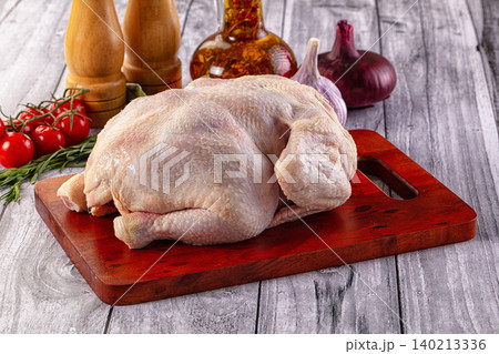 Raw whole chicken on wooden board with ingredients Raw whole chicken on wooden board with ingredients 140213336