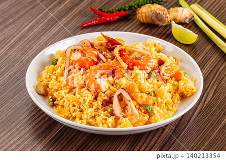 Flavorful Asian fried rice with succulent prawns, tender calamari, vibrant vegetables, and aromatic spices. Delicious seafood entree Flavorful Asian fried rice with succulent prawns, tender calamari, vibrant vegetables, and aromatic spices. Delicious seafood entree 140213354