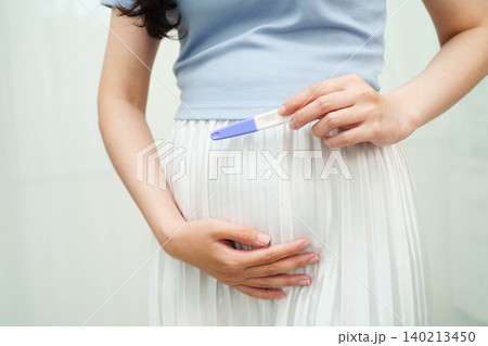 Asian holding pregnancy test for female of ovulation day, fetus, maternity, childbirth, birth control. 140213450