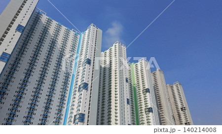 Low-angle view of modern high-rise residential apartment buildings against a blue sky Low-angle view of modern high-rise residential apartment buildings against a blue sky 140214008