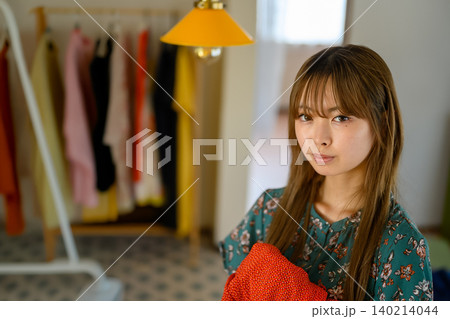 部屋で服を選ぶ女性 部屋で服を選ぶ女性 140214044