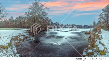 Frozen Fish Pond under Pastel Winter Sunset Sky Frozen Fish Pond under Pastel Winter Sunset Sky 140214167