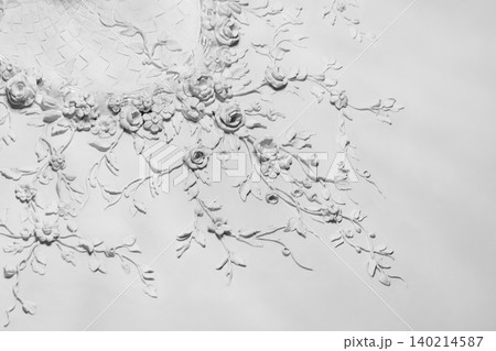 White plaster floral relief forming an ornate ceiling White plaster floral relief forming an ornate ceiling 140214587