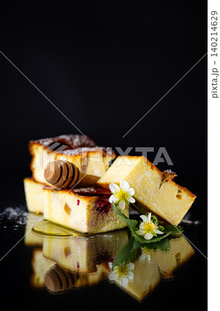 Baked cottage cheese squares with strawberry pieces on dark background Baked cottage cheese squares with strawberry pieces on dark background 140214629