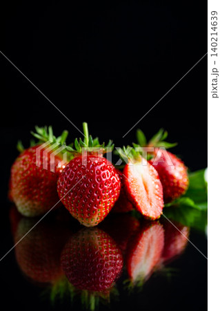 Red strawberry berries on dark reflective surface 140214639