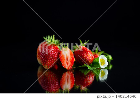 Juicy organic strawberries with green leaves on black background 140214640