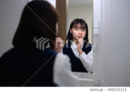 鏡の前で歯磨きする女性 鏡の前で歯磨きする女性 140215121