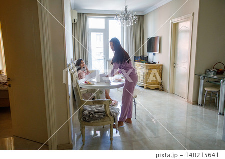 Attractive mother and daughter together at home. Breakfast or lunch Attractive mother and daughter together at home. Breakfast or lunch 140215641