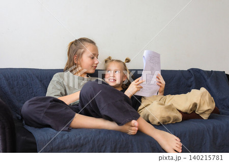 Laughing children reading and learning at home Laughing children reading and learning at home 140215781