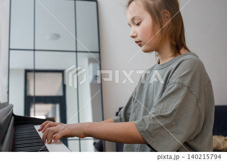 Adorable boy studying music at home. Blonde child playing on the piano Adorable boy studying music at home. Blonde child playing on the piano 140215794