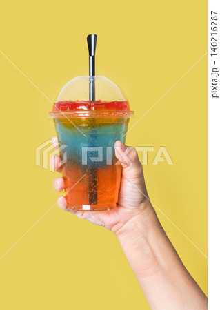 Person holding a colorful layered slushie drink Person holding a colorful layered slushie drink 140216287
