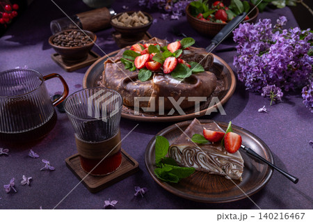 Chocolate crepe cake with strawberries and coffee on purple table Chocolate crepe cake with strawberries and coffee on purple table 140216467