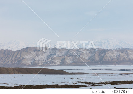 Toktogul reservoir winter panorama with snowcapped mountains and frozen shoreline Toktogul reservoir winter panorama with snowcapped mountains and frozen shoreline 140217059