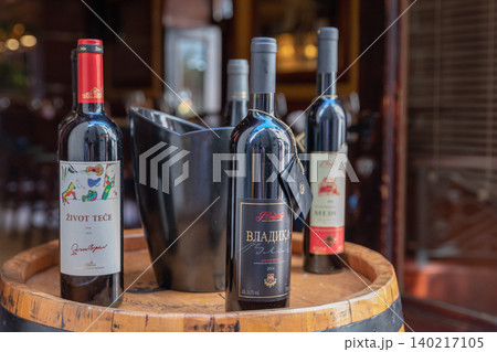 Wine bottles on wooden barrel table in Kotor restaurant interior, Montenegro Wine bottles on wooden barrel table in Kotor restaurant interior, Montenegro 140217105