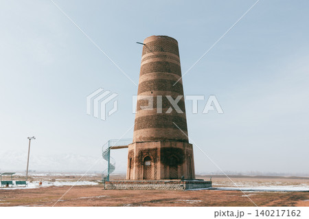Burana Tower ancient minaret in Tokmok, Kyrgyzstan with winter steppe landscape Burana Tower ancient minaret in Tokmok, Kyrgyzstan with winter steppe landscape 140217162