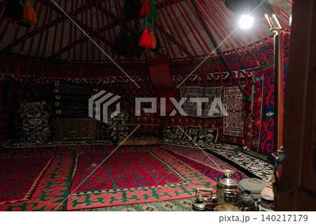 Traditional Kyrgyz yurt interior with colorful carpets at Ruh Ordo complex 140217179