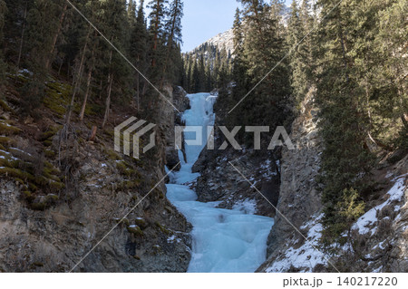 Boroda Aksakala waterfall frozen in winter gorge with pine forest, Kyrgyzstan Boroda Aksakala waterfall frozen in winter gorge with pine forest, Kyrgyzstan 140217220