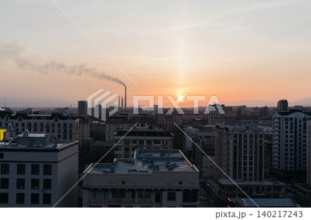 Bishkek city skyline at sunset with industrial smokestacks and haze pollution 140217243