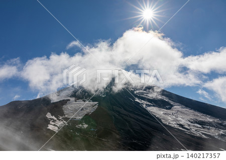 Avachinsky volcano summit with clouds and sunburst, Kamchatka landscape view Avachinsky volcano summit with clouds and sunburst, Kamchatka landscape view 140217357