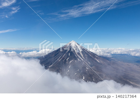 Koryaksky volcano peak rising above clouds under clear blue sky, Kamchatka 140217364