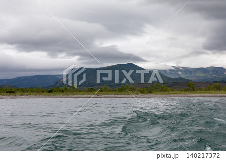 Stormy landscape at Kuril Lake with volcanic mountains and choppy water Stormy landscape at Kuril Lake with volcanic mountains and choppy water 140217372