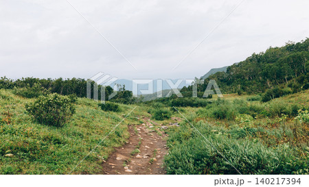 Hiking trail in Vachkazhets mountain range with green valley and misty peaks Hiking trail in Vachkazhets mountain range with green valley and misty peaks 140217394
