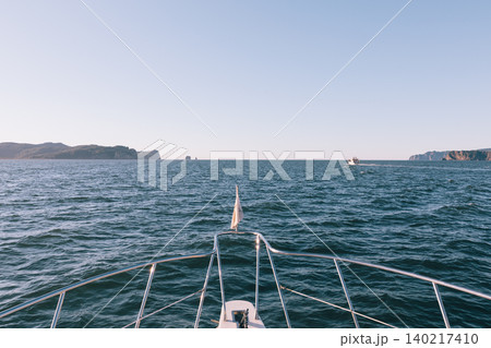 Boat bow view on the Pacific Ocean near Kamchatka coastline with clear sky Boat bow view on the Pacific Ocean near Kamchatka coastline with clear sky 140217410