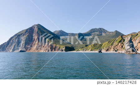 Rugged volcanic coastline and green mountains on Kamchatka Peninsula, Russia Rugged volcanic coastline and green mountains on Kamchatka Peninsula, Russia 140217428