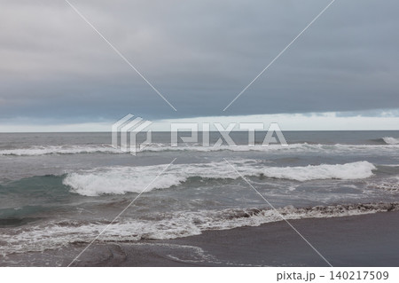 Stormy sea with breaking waves and dark clouds over an empty shoreline Stormy sea with breaking waves and dark clouds over an empty shoreline 140217509