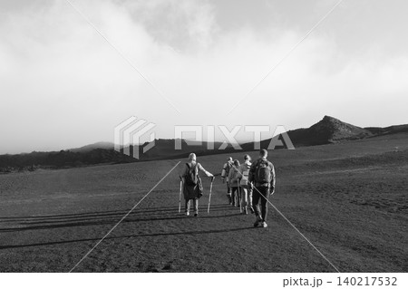 Hiking group trekking across volcanic landscape in Tolbachinsky Dol at sunrise Hiking group trekking across volcanic landscape in Tolbachinsky Dol at sunrise 140217532