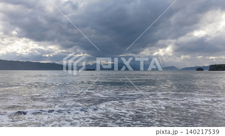 Stormy seascape with sun rays over Avacha Bay coastline in Kamchatka Peninsula 140217539