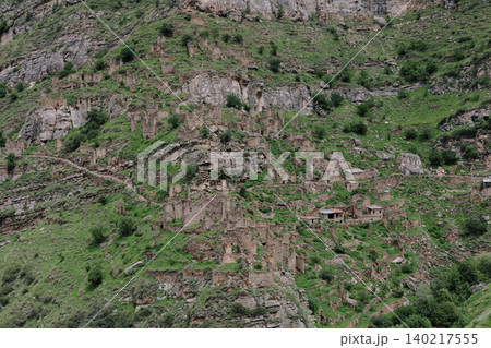 Ruins of the old mountain village of Kahib on a rocky green slope in Dagestan Ruins of the old mountain village of Kahib on a rocky green slope in Dagestan 140217555